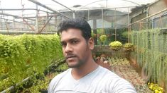 a man standing in front of some plants