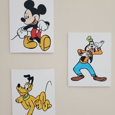 three mickey mouse stickers on a wall next to a dog and a cartoon character