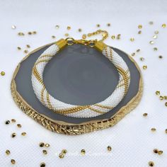 two white and gold bracelets sitting on top of a table