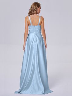 a woman in a long blue dress is looking back at the camera and she has her hands on her hips