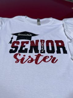 Senior Graduation t-shirts. The graduation cap can be customized with your graduate's name, and the year your graduate is graduating can be customized on the letter I in senior.  You can also customize for the family members by telling me which name to put at the bottom, ex. Mom, Dad, Brother, Sister, Cousin, Aunt, Uncle, Grandma, Grandpa, etc. Pick your shirt color and also tell me in the notes section what your school colors are to customize for you. These shirts can also be done with glitter colors if you want to add sparkle to your shirt. You also have the option to add words to the back of the shirt at an extra price. Make sure to select the option under the drop-down menu. Graduation T Shirt Ideas For Family, Graduation Shirts For Girlfriend, Proud Sister Of A Graduate Shirt, Senior Graduation Shirts, Cute Graduation Shirts, Proud Friend Of A Senior Cheer Shirt, Senior Sister Shirts, Senior Shirts For Family, Senior Family Shirts