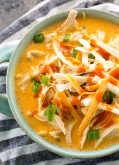 a bowl of soup with shredded cheese and vegetables