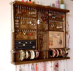 a wall mounted jewelry rack filled with lots of necklaces