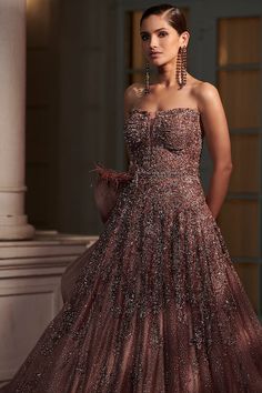 Editor's Note This is a stunning claret-colored fitted gown made of shimmer tulle fabric with an ombre effect. It features intricate feather embellishments and a dramatic trail for a show-stopping look. Fabric: Tulle Color: Pink Components: Gown Occasion: Reception Disclaimer: Product color may slightly vary due to photographic lighting sources or your monitor setting. Care: Dry clean only About the Designer Dolly J is an Indian occasion wear label known for their modern take on traditional silh Trail Gown, Dolly J, Ombre Gown, Purple Tulle, Fitted Gown, Fitted Gowns, Gown For Women, Off Shoulder Gown, Wild Cherry