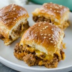 three cheeseburger sliders on a white plate