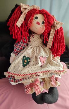 a red haired doll sitting on top of a bed