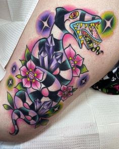 a woman's leg with a shark and flowers on it