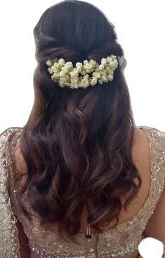 the back of a woman's head with long hair and flowers in her hair