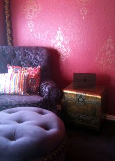 a chair and ottoman in a room with red walls