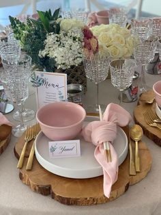 the table is set with pink dishes and place settings