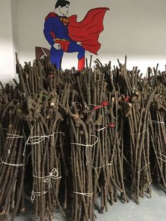 a bunch of sticks that have been wrapped in rope with a superman sign on top