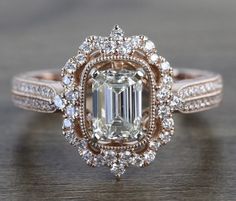 an emerald colored diamond surrounded by white and brown diamonds on top of a wooden table