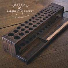 a wooden peg board with holes in the middle on a wood table, and an ad for leather supply written above it