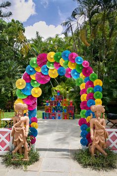 an archway made out of paper plates with statues