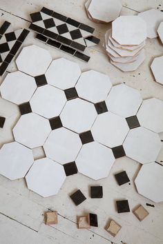 several pieces of black and white tile laying on the floor next to some wooden blocks