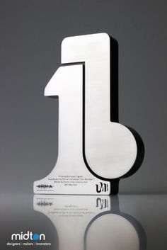 a white and black number one sign sitting on top of a reflective surface with reflection