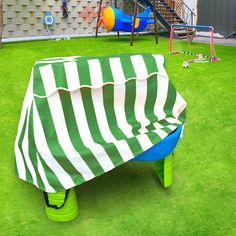 a green and white striped cover sitting on top of a field