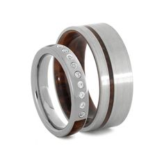 two wedding rings with wood inlays and diamonds on each side, set against a white background