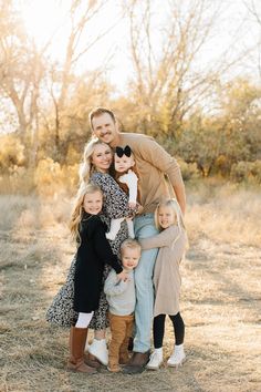 a family poses for a photo in an open field