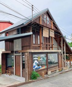 an old wooden building with many windows on the front and side of it, along with power lines in the background