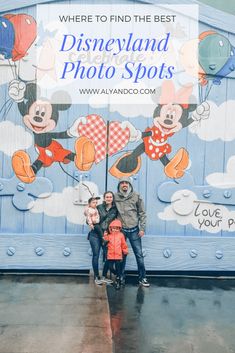 family posing in front of the disneyland photo spots sign with mickey mouses on it