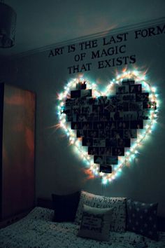 a heart made out of photos is on the wall above a bed with pillows and blankets