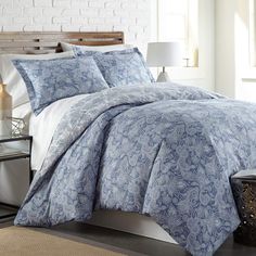 a bed with blue and white comforters in a bedroom