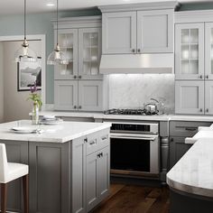 a kitchen with gray cabinets and white counter tops