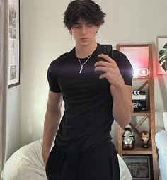 a young man taking a selfie in his bedroom