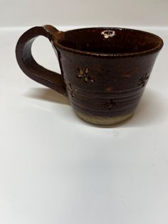 a brown cup sitting on top of a white table