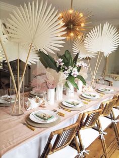 a long table with plates and flowers on it