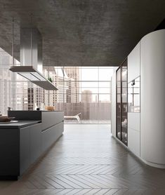 an empty kitchen with white cabinets and black counter tops, in front of large windows