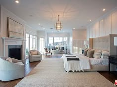 a large bedroom with white furniture and wood floors