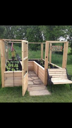 a wooden garden bench sitting on top of a lush green field with lots of plants