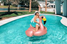 a woman is sitting on an inflatable flamingo pool float at the edge of a swimming pool