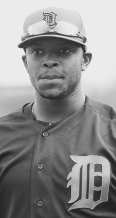 a black and white photo of a baseball player wearing a uniform with the detroit tigers on it