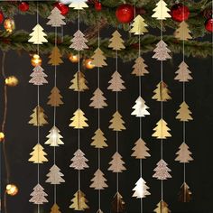 a christmas tree mobile hanging from the ceiling next to a christmas tree with lights on it