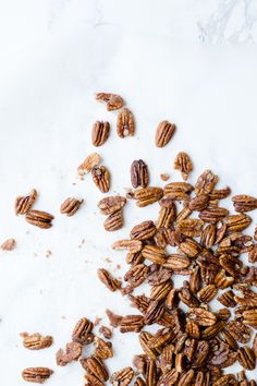 candied pecans on a white surface with text overlay that reads, cinnamon coated pecans