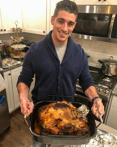 a man holding a roasting pan full of food