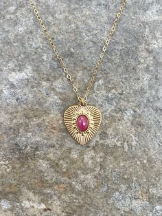 This necklace is handcrafted with an authentic 4x6mm ruby stone in a 19x16mm 14k gold-plated stainless steel setting. The stone is AAA quality. The chain is 14k gold-filled and will not tarnish easily.  Ruby is an energizing stone that promotes passion and optimism. Each necklace comes in a ribbon-wrapped box, ready to be gifted. If you would like to leave a note for the recipient, you can do so during checkout. Gold Heart-shaped Birthstone Necklace With Gemstone, Gold Heart-shaped Birthstone Necklace, Gold Ruby Heart Pendant Jewelry, Gold Pendant Heart Necklace With Gemstone, Heart-shaped Ruby Necklace In Yellow Gold, Gold Birthstone Necklace With Heart Charm For Valentine's Day, Gold Plated Birthstone Necklaces For Valentine's Day, Gold Heart-shaped Gemstone Jewelry, Gold Stainless Steel Jewelry With Birthstone