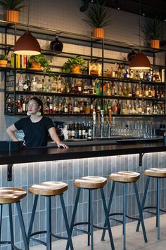 a woman sitting at a bar with four stools