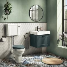 a bathroom with a toilet, sink and mirror next to a window in the room