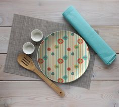 an empty plate and wooden spoons on a place mat