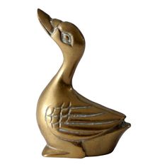 a golden duck statue sitting on top of a white surface