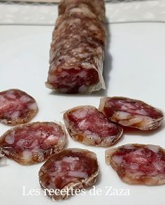 several pieces of meat on a white plate