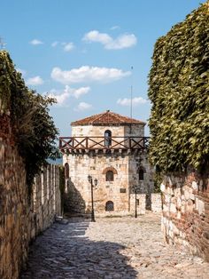 an old stone building with a clock tower in the middle of it's courtyard