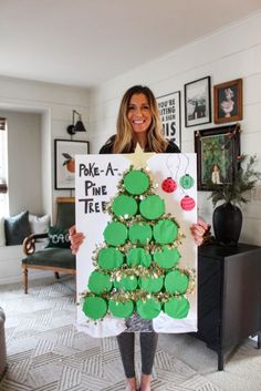 a woman holding up a sign with a christmas tree on it