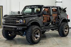 a large black truck with brown seats in the back and on the front, parked in a garage