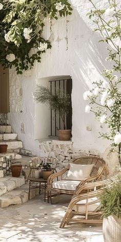 an outdoor area with chairs and flowers on the ground, next to a stone building