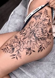 a woman's thigh with flowers on it and a ribbon around her waist that says,